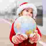 Kind mit Weihnachtsmütze und Globus